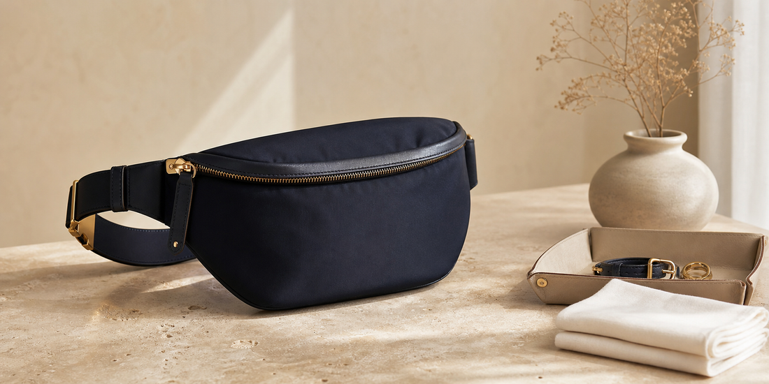 Unbranded navy belt bag on a warm stone surface with a leather tray and care cloth