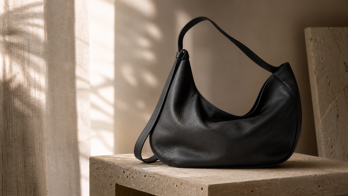Unbranded black soft leather slouchy shoulder bag in a neutral editorial studio